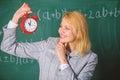 Woman teacher hold alarm clock. Girl school lecturer. What time is it. Lessons schedule. Welcome teacher school year