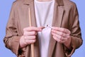 Woman teacher holding broken cigarette on studio blue background, close-up Royalty Free Stock Photo