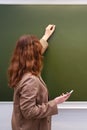 Woman teacher writes a text in chalk on a school blackboard Royalty Free Stock Photo