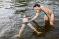 Woman teaches the child to stay on the water in the Lake Royalty Free Stock Photo