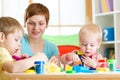 Woman teaches children handcraft at kindergarten or playschool