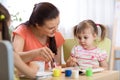 Woman teaches kids painting at kindergarten or playschool