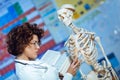 Woman teaching anatomy using human skeleton model