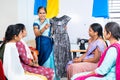 Woman teaching cloth design to students at tailoring training centre - concept of learning, employment and workshop. Royalty Free Stock Photo