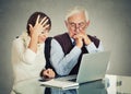 Woman teaching confused elderly man how to use laptop Royalty Free Stock Photo