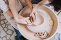 Woman and a boy shaping clay bowl on a pottery wheel. Top view Royalty Free Stock Photo