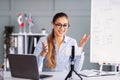 Woman Teaching Online Class With a Laptop and Whiteboard in a Well-Lit Office Space Royalty Free Stock Photo