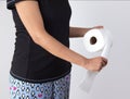 Woman tearing tissue from toilet paper roll Royalty Free Stock Photo