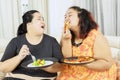 Woman teasing her fat sister on diet with pizza