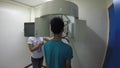 Woman technician assists Dental patient undergoes skull x-ray