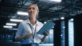 Woman IT Technician Works on Tablet Computer in Big Data Center at Night. She Runs Diagnostics and Royalty Free Stock Photo