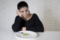 Woman or teen with fork eating dish with ridiculous little lettuce as her food symbol of crazy diet Royalty Free Stock Photo