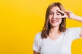 Woman teen smile standing wear t-shirt showing finger making v-sign symbol near eye Royalty Free Stock Photo