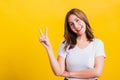 Woman teen smile standing wear t-shirt showing finger making v-sign symbol near eye Royalty Free Stock Photo