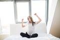 woman or teenage girl in headphones listening to music from smartphone and dancing on bed at home Royalty Free Stock Photo