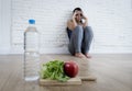 Woman or teenager girl sitting on ground alone worried at home suffering nutrition eating disorder Royalty Free Stock Photo