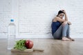 Woman or teenager girl sitting on ground alone worried at home suffering nutrition eating disorder Royalty Free Stock Photo