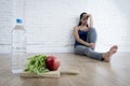 Woman or teenager girl sitting on ground alone worried at home suffering nutrition eating disorder Royalty Free Stock Photo