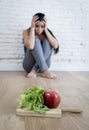 Woman or teenager girl sitting on ground alone worried at home suffering nutrition eating disorder Royalty Free Stock Photo