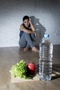 Woman or teenager girl sitting on ground alone worried at home suffering nutrition eating disorder