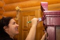 Woman with teeth smile on face painting ornamented cupboard in pink with big paint brush with doors in background. Reuse Royalty Free Stock Photo