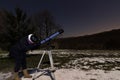 Woman with telescope under winter night sky Woman looking through telescope under starry night. Royalty Free Stock Photo