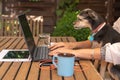 Woman teleworking from home with her dog looking at laptop screen, Royalty Free Stock Photo