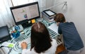 Woman teleworking at home while her son studies