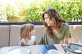 Woman telling a happy story to little girl in restaurant Royalty Free Stock Photo