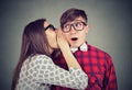 Woman telling whispering secret gossip in the ear to an amazed shocked man Royalty Free Stock Photo