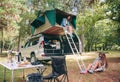 Woman in tent over 4x4 and other putting hiking Royalty Free Stock Photo