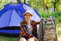 Woman tent summer. Defocus young woman sitting near camping tent outdoors surrounded by beautiful nature. Freelance