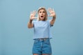 Woman terrified screaming and asking stop. Portrait of shocked panicking troubled blonde female in denim shorts and