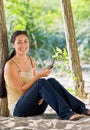 Woman text messaging on cell phone at beach