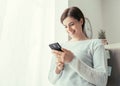 Woman texting in the kitchen