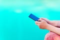 Woman texting on mobile phone by the swimming pool Royalty Free Stock Photo