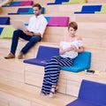 Woman texting on phone and man browsing with modern notebook Royalty Free Stock Photo