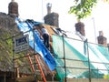 Woman thatcher repairing roof.