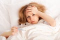 Woman with thermometer sick colds, flu, fever in bed Royalty Free Stock Photo