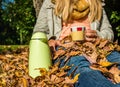 Woman with thermos can in the autumn park