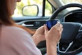 Woman with thermos cap driving car, closeup