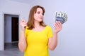 Woman think over investment in new home with keys and American dollars in hand, close-up. Money to buy furniture, designer and Royalty Free Stock Photo