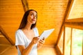 Woman thinking with digital tablet in the wooden