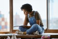 Woman, thinking and drawing by window in art studio, Indian creative gallery and designer workshop. Artist, painter or