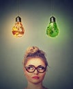 Woman thinking looking up at junk food and green vegetables shaped as light bulb above head Royalty Free Stock Photo