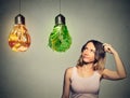 Woman thinking looking up at junk food and green vegetables shaped as light bulb Royalty Free Stock Photo
