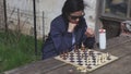 Woman thinking near chess board