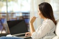 Woman thinking using a laptop with blank screen Royalty Free Stock Photo