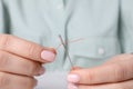 Woman threading needle, closeup view. Sewing equipment