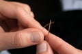 Woman threading sewing needle on blurred background, closeup